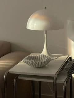 White marble fruit bowl with fluted design on a side table, home decor accent.